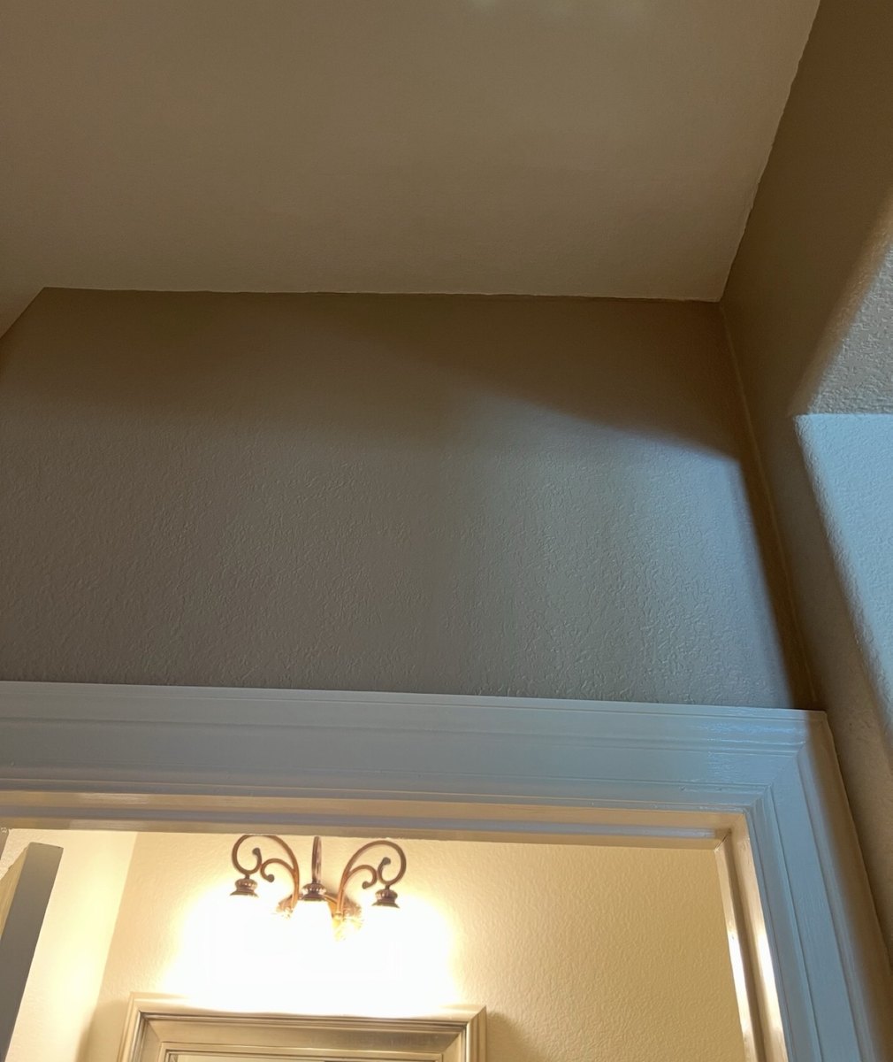 After - finished drywall repair above doorway, smooth painted surface