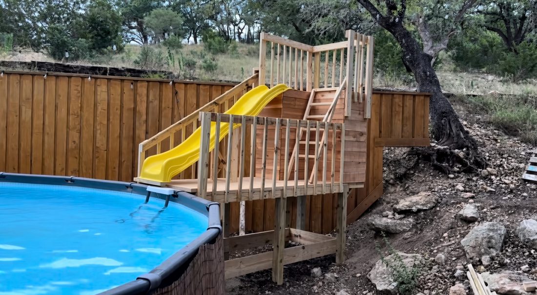 After - finished poolside wooden play structure with stairs, platform and yellow slide