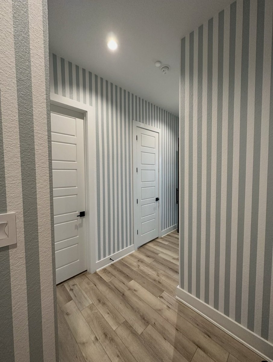 After - hallway with vertical blue-gray wall stripes
